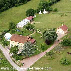Charmante maison de campagne avec piscine, entourée de verdure et tipis.