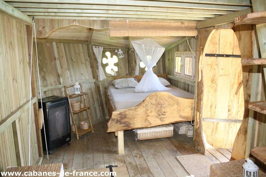 1502 Cabane en bois en Bretagne, avec lit en bois sculpté et fenêtres décoratives.