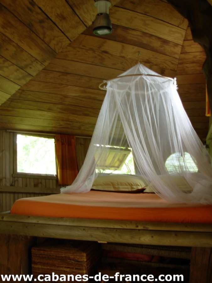 1509 Cabane en bois en Bretagne avec un lit à baldaquin et une ambiance chaleureuse.