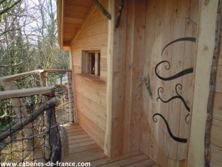 154 Cabane en bois perchée, avec un balcon en bois et une porte décorative originale.