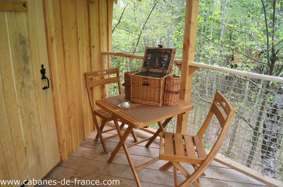 1655 Cabane perchée en Auvergne-Rhône-Alpes avec terrasse en bois et panier pique-nique.