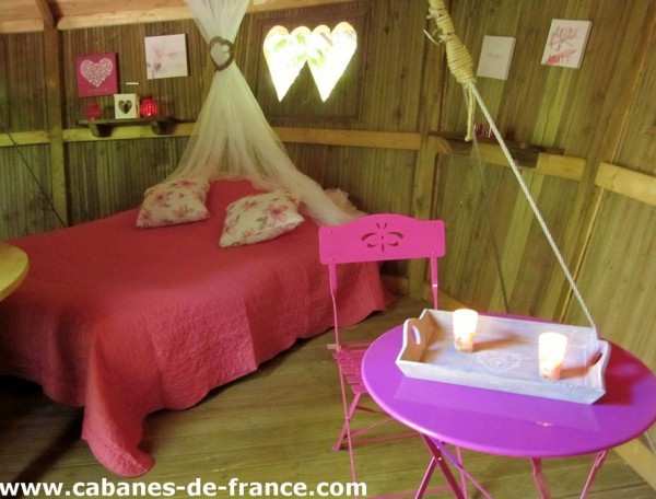 Cabane romantique à Champagne-Ardenne, avec lit douillet et mobilier coloré.