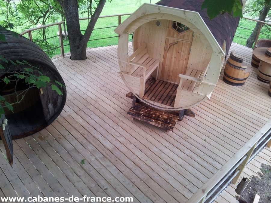 1840 Hébergement insolite en forme de tonneau, situé sur une terrasse en bois.