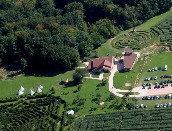Cabanes en pleine nature avec vue sur un jardin labyrinthique verdoyant.