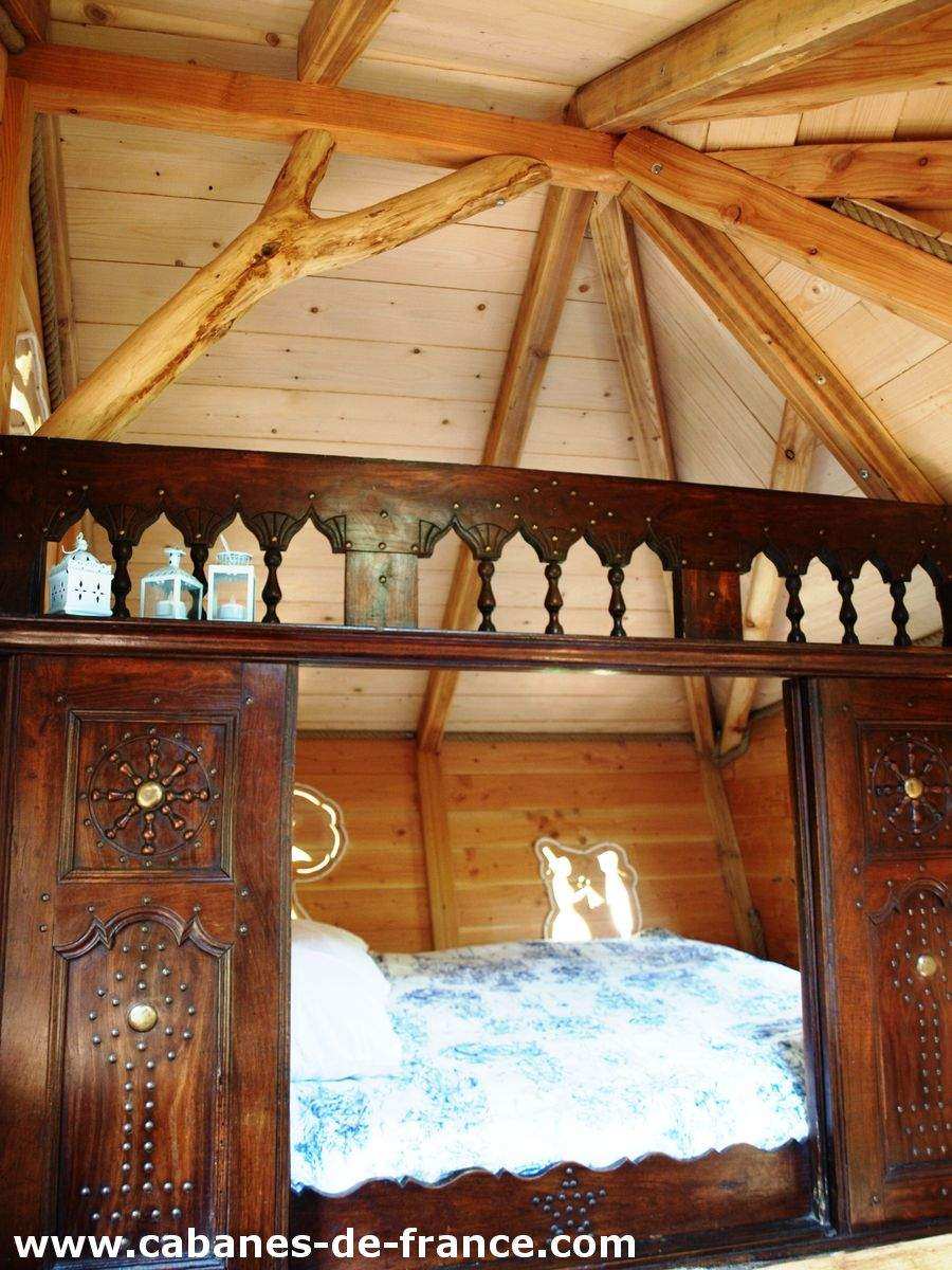 3021 Cabane en bois en Bretagne avec un lit douillet et des lanternes décoratives.