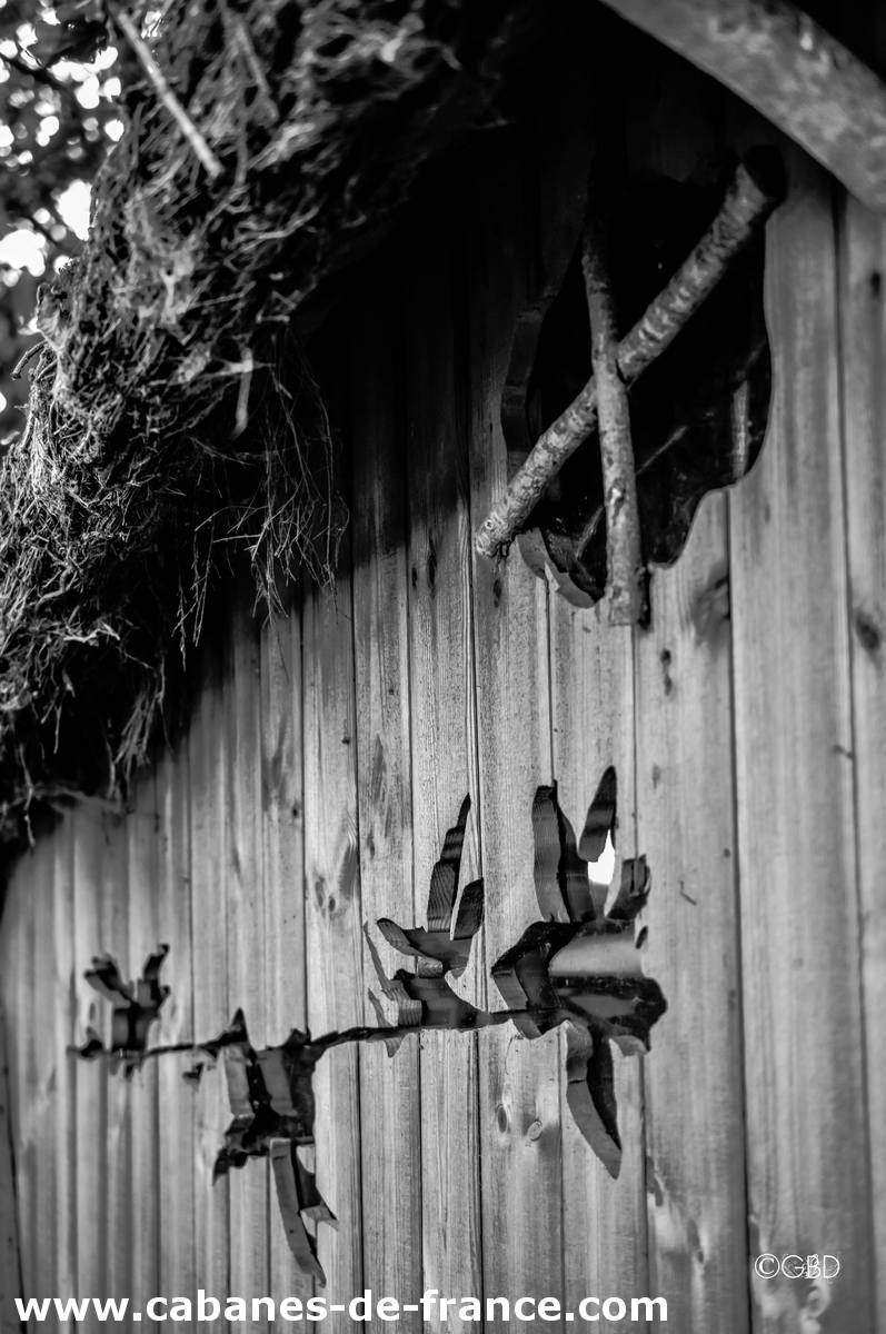 3074 Cabane en bois en Bretagne, ornée de découpes artistiques sur la façade.
