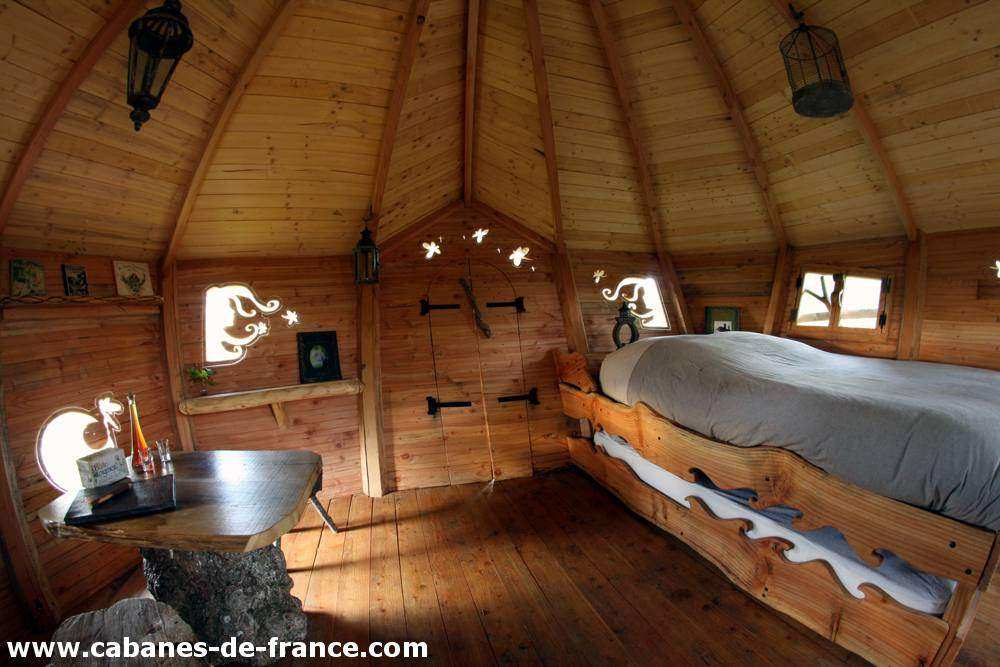 3085 Cabane en bois en Bretagne, intérieur chaleureux avec lit en bois sculpté.