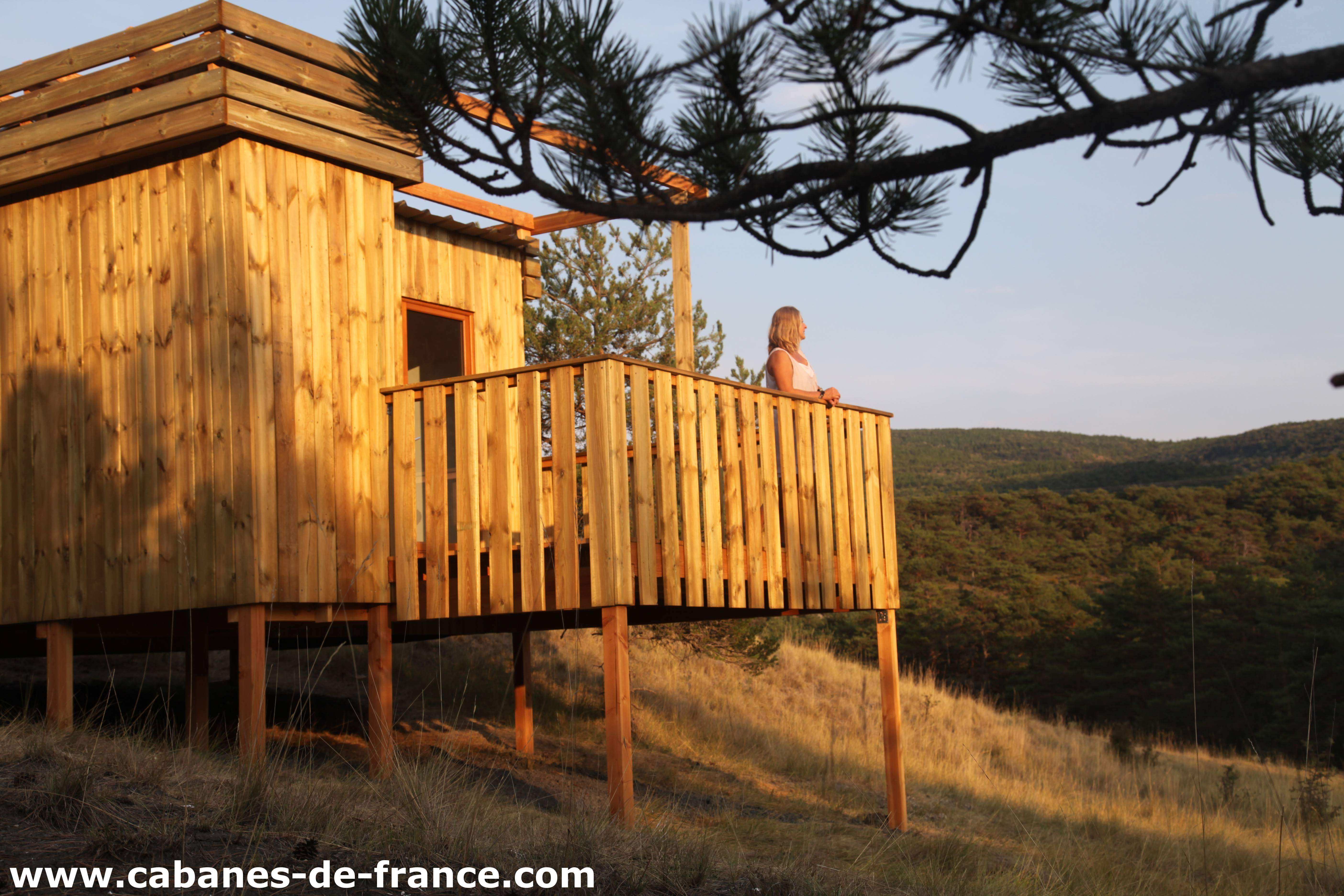 Cabane en bois sur pilotis, offrant une vue panoramique sur la nature environnante.