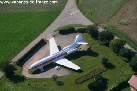 499 Hébergement insolite : avion reconverti en gîte, entouré de verdure.
