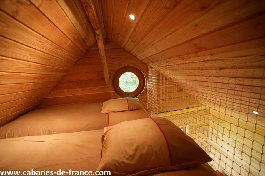 517 Cabane en bois à Champagne-Ardennes, avec lits douillets et fenêtre ronde.