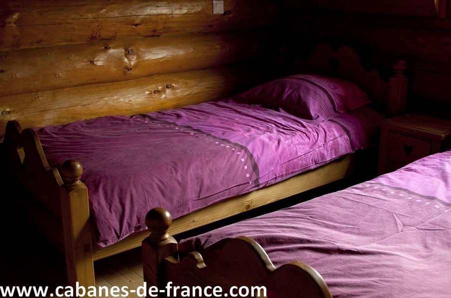 742 Chalet en bois en Auvergne avec lits jumeaux et draps violets. Ambiance chaleureuse.