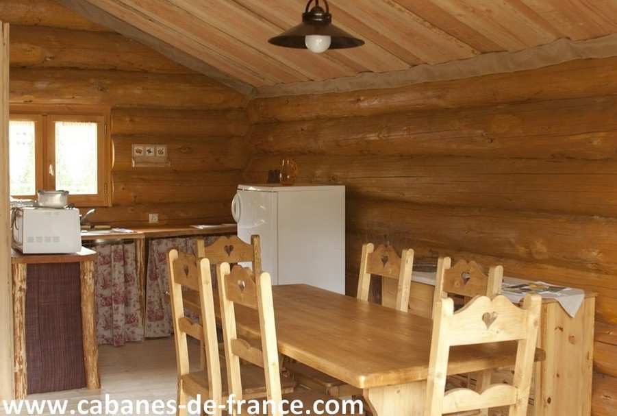 744 Cabane en bois en Auvergne, avec une table en bois et des chaises rustiques.