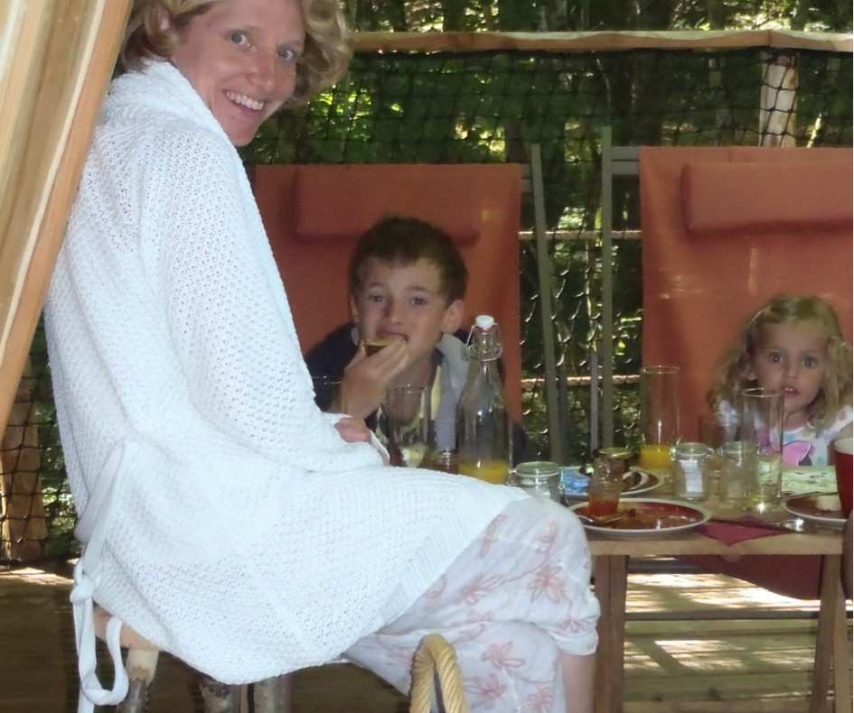 Tente lodge en pleine nature, famille profitant dun repas convivial en extérieur.