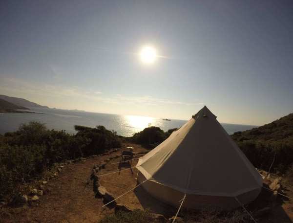 Tente de glamping avec vue sur la mer et le soleil levant. Ambiance paisible et naturelle.