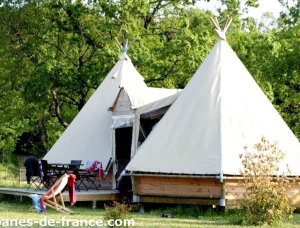 Tentes tipis spacieuses en pleine nature, avec terrasse et mobilier extérieur.