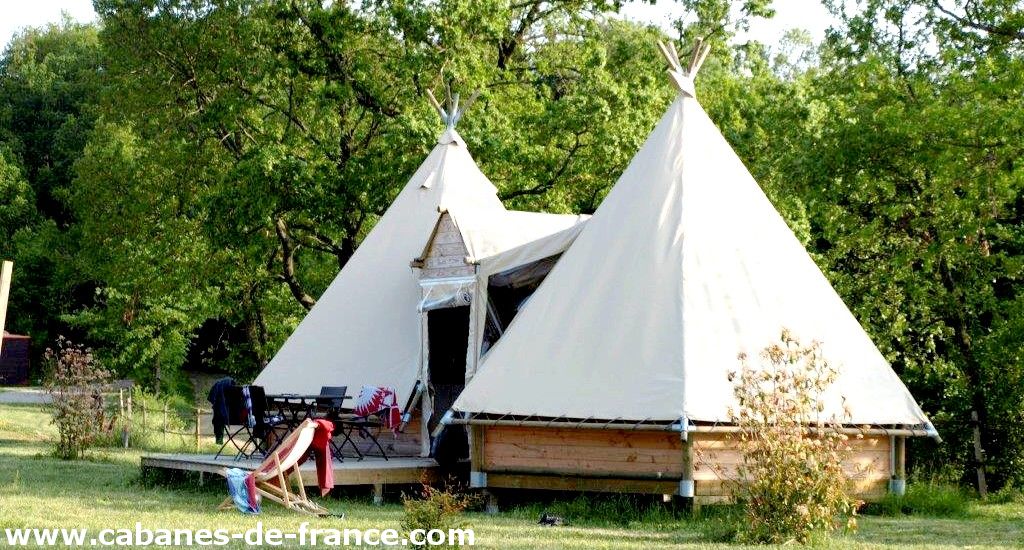 Tentes tipis spacieuses en pleine nature, avec terrasse et mobilier extérieur.