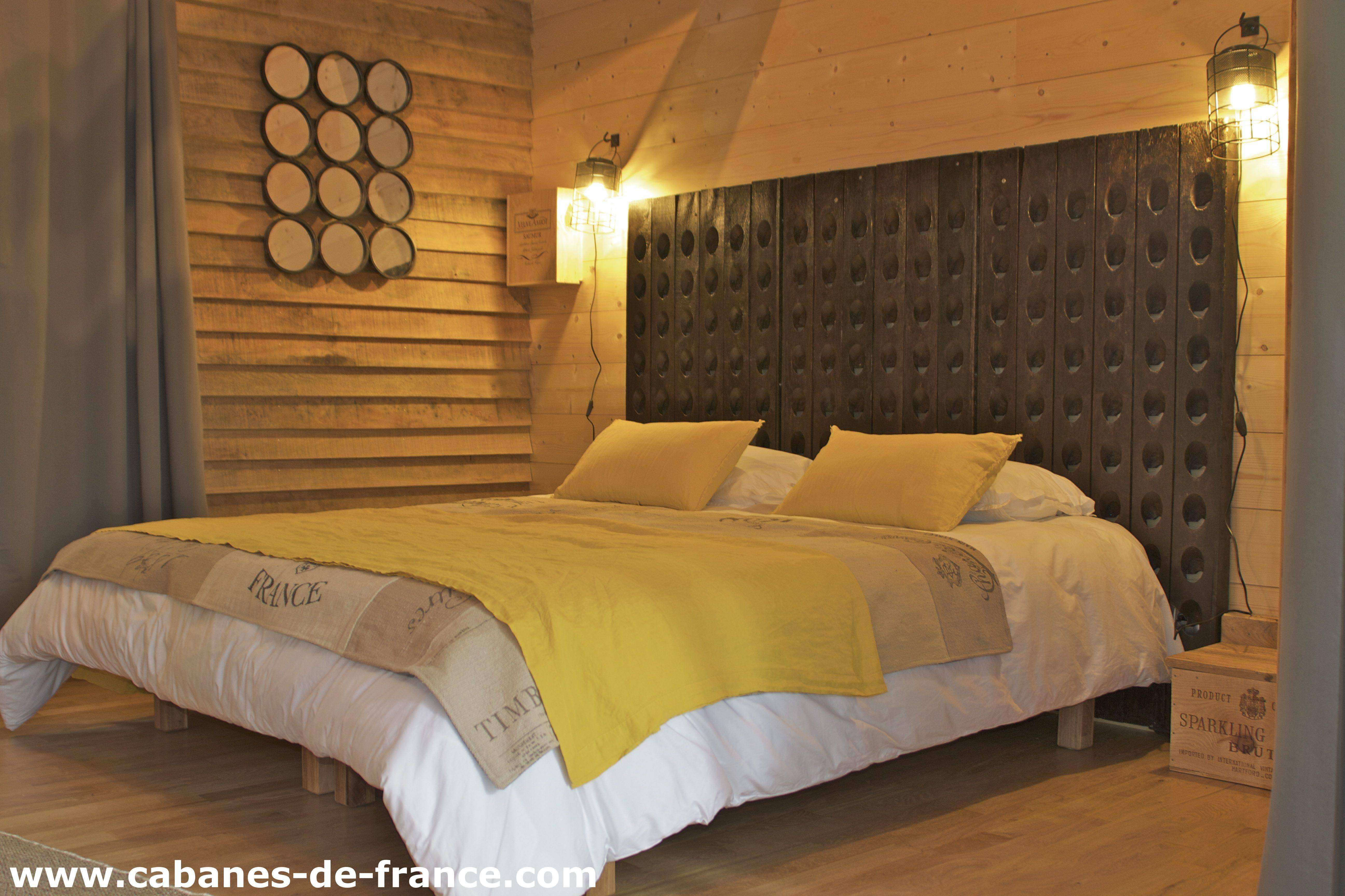 Chalet en bois avec un lit douillet et des murs en panneaux de bois chaleureux.