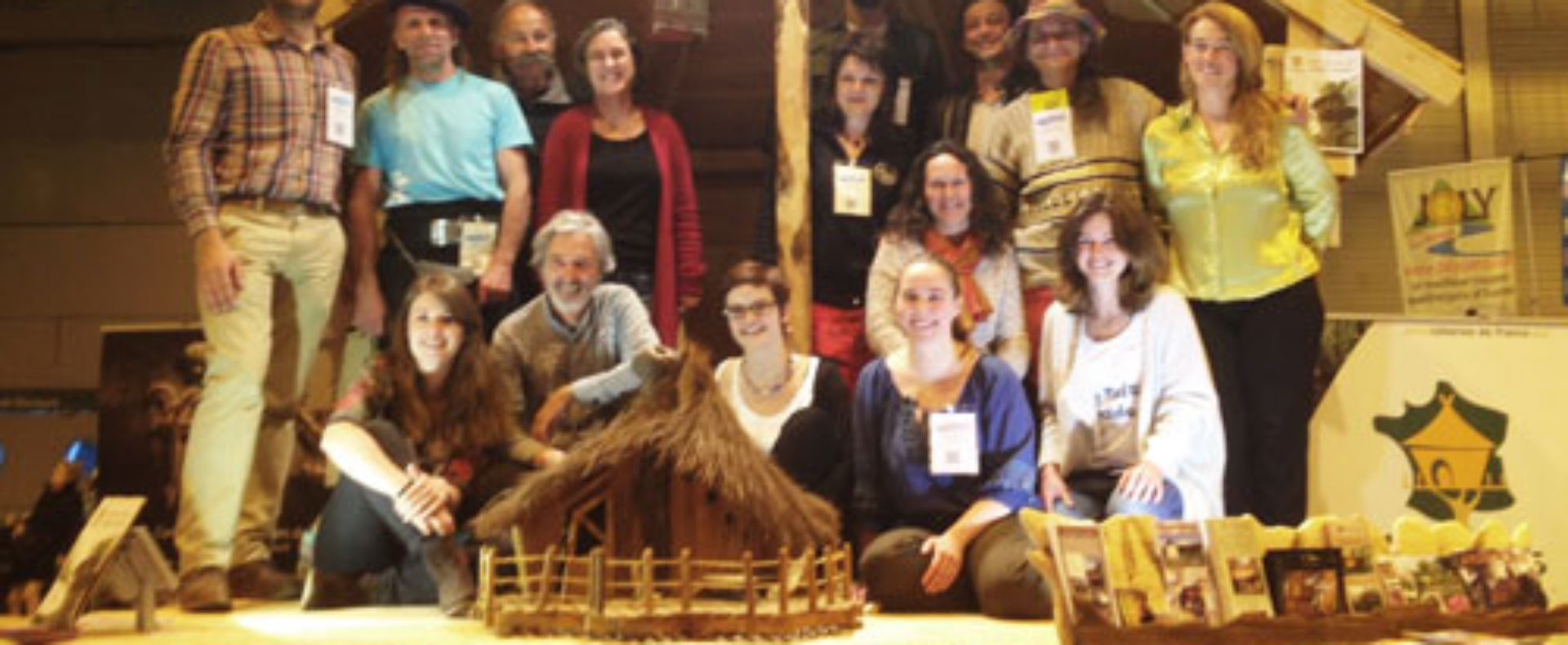 Groupe de personnes devant un chalet en bois, représentant un hébergement touristique.