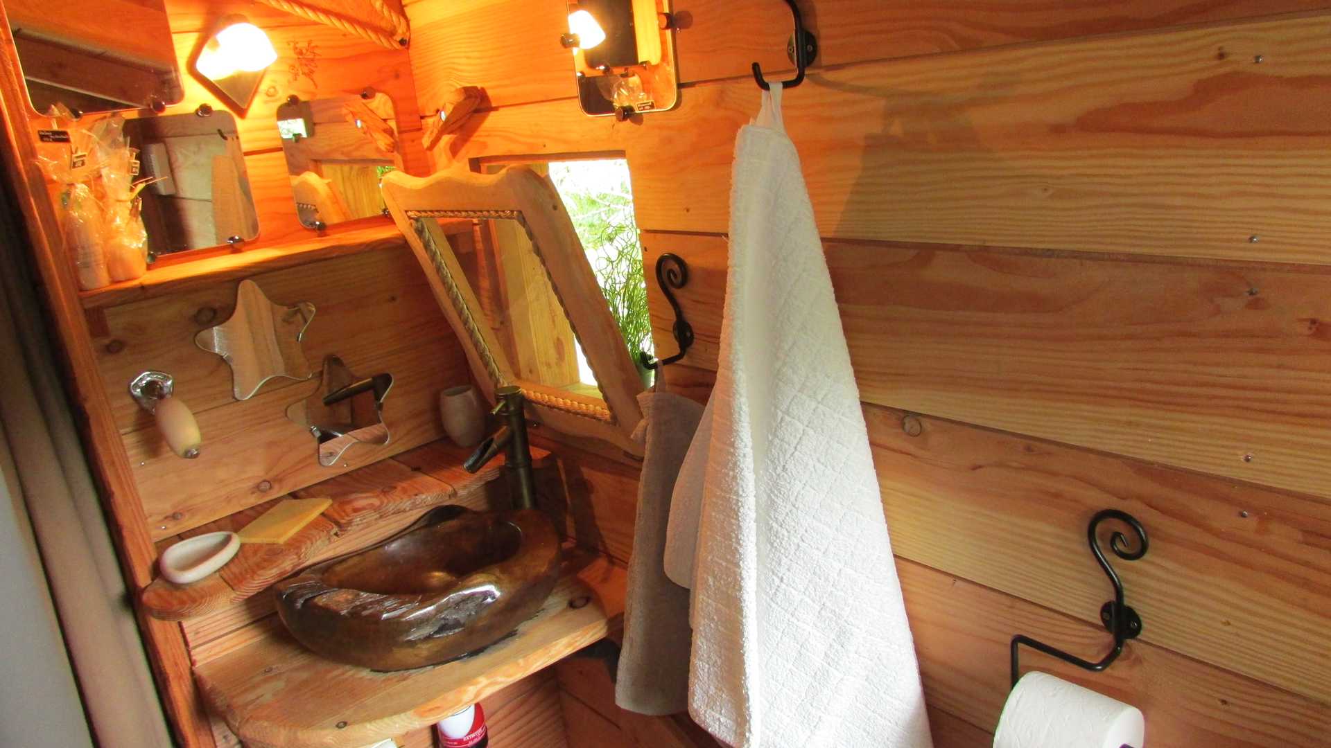 aout 2014 005 Intérieur dun hébergement insolite en Bretagne, avec un lavabo en bois et des murs en bois.