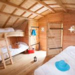 Chalet en bois chaleureux avec lits superposés et décor nautique.