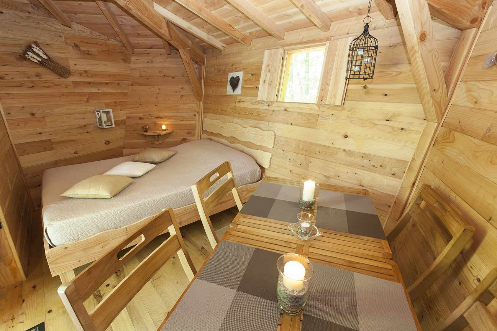 photojp-angei-jp-angei2497 Cabane en bois cosy avec lit douillet et table en bois, ambiance chaleureuse.