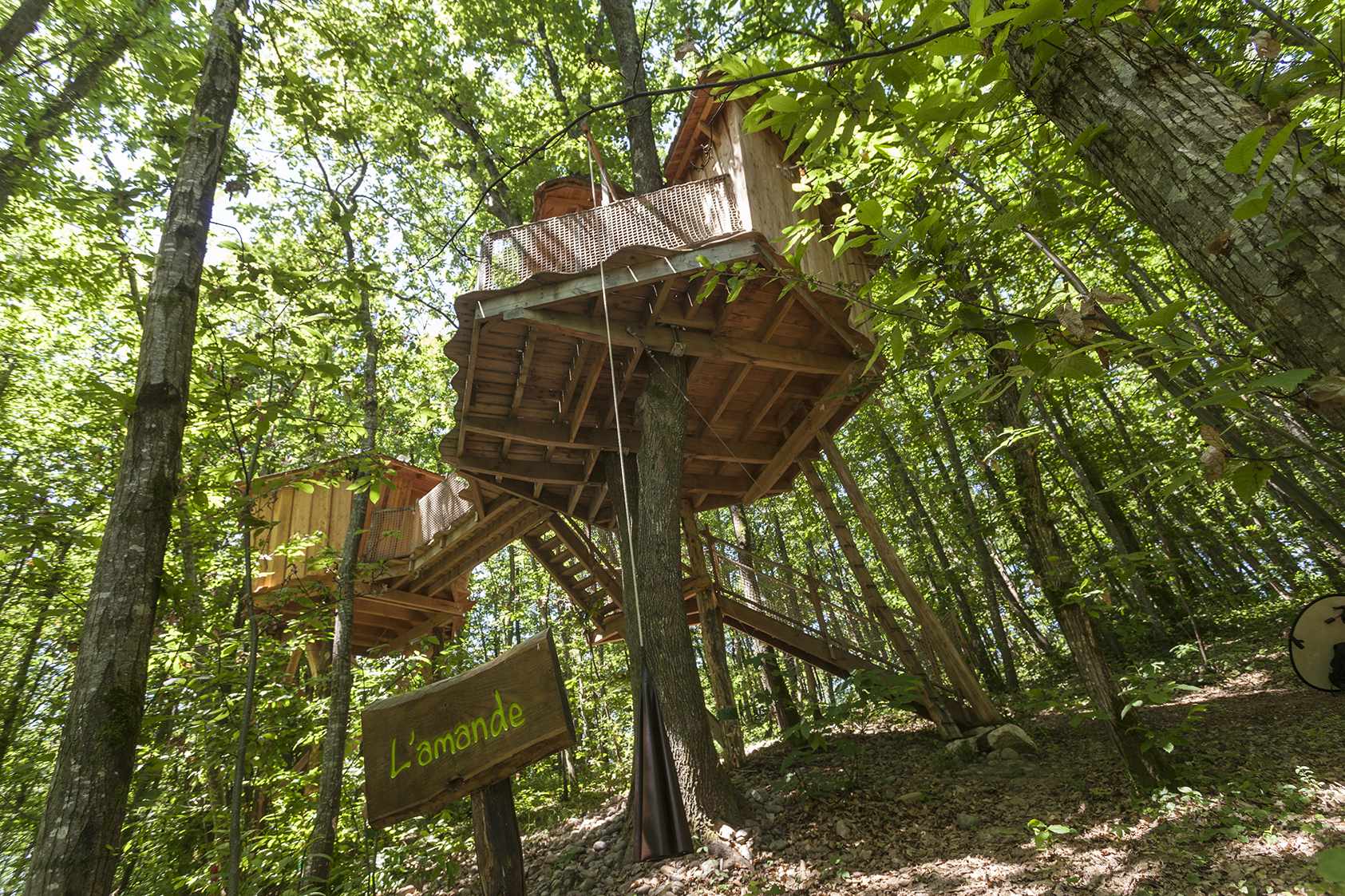 photojp-angei-jp-angei2502 Cabane perchée dans les arbres, entourée de verdure luxuriante en Auvergne-Rhône-Alpes.