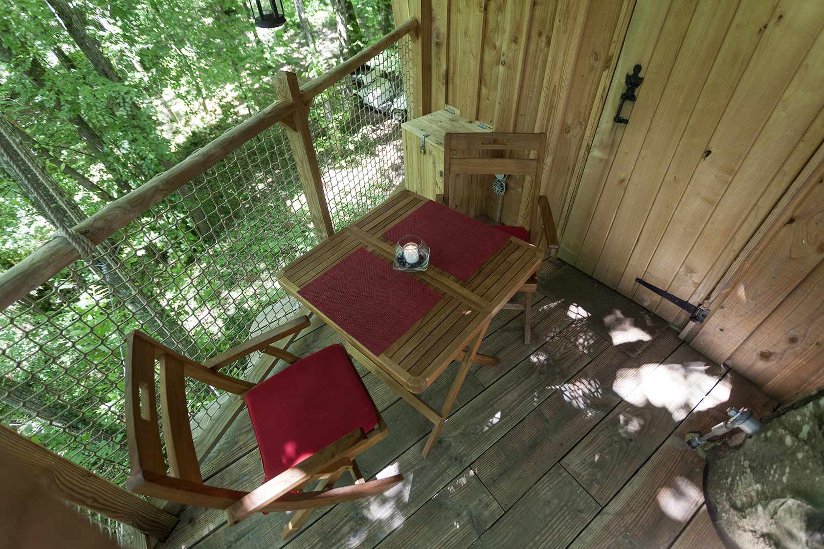 photojp-angei-jp-angei2523 Cabane perchée en Auvergne-Rhône-Alpes avec une terrasse en bois et chaises confortables.