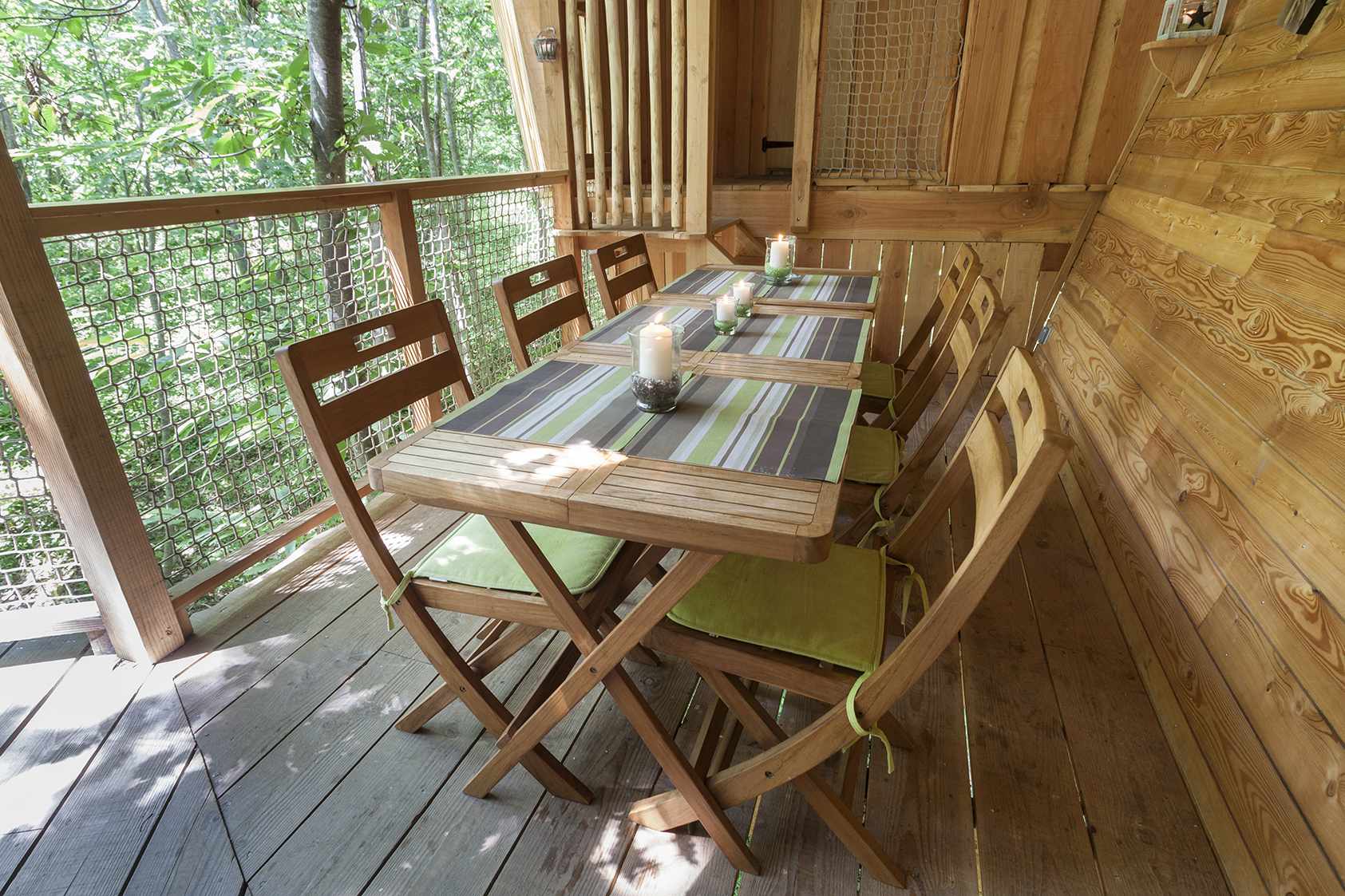 photojp-angei-jp-angei2583 Cabane perchée en bois avec une table en bois et des chaises, entourée de verdure.