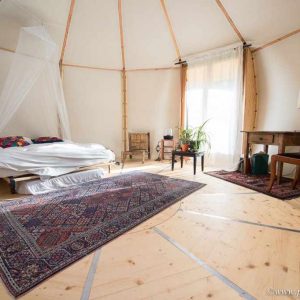 Tente glamping spacieuse avec lit douillet et décoration chaleureuse.
