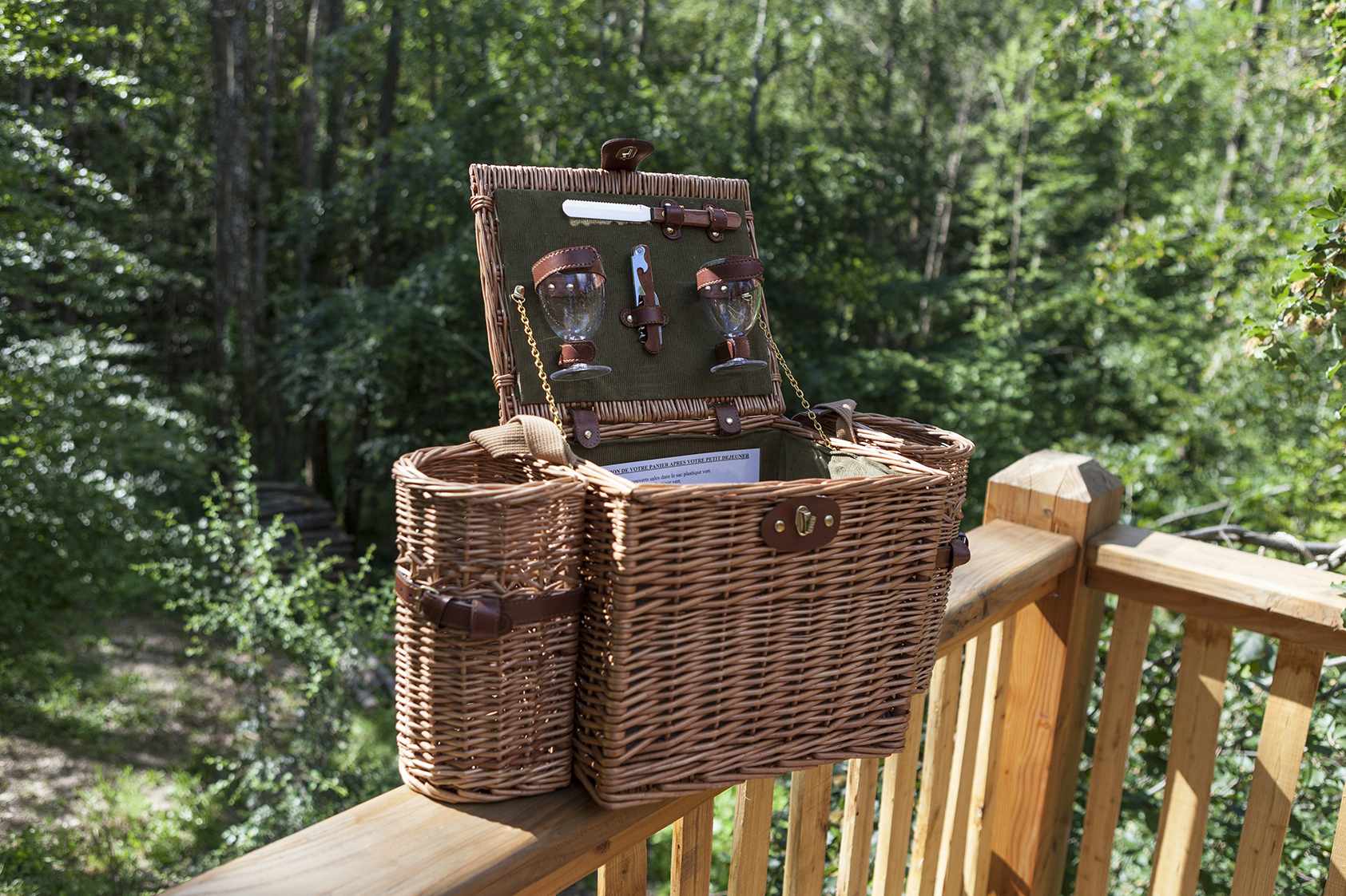 photojp-angei-jp-angei2467 Panier pique-nique en osier sur une terrasse bois, entouré de verdure en Auvergne-Rhône-Alpes.