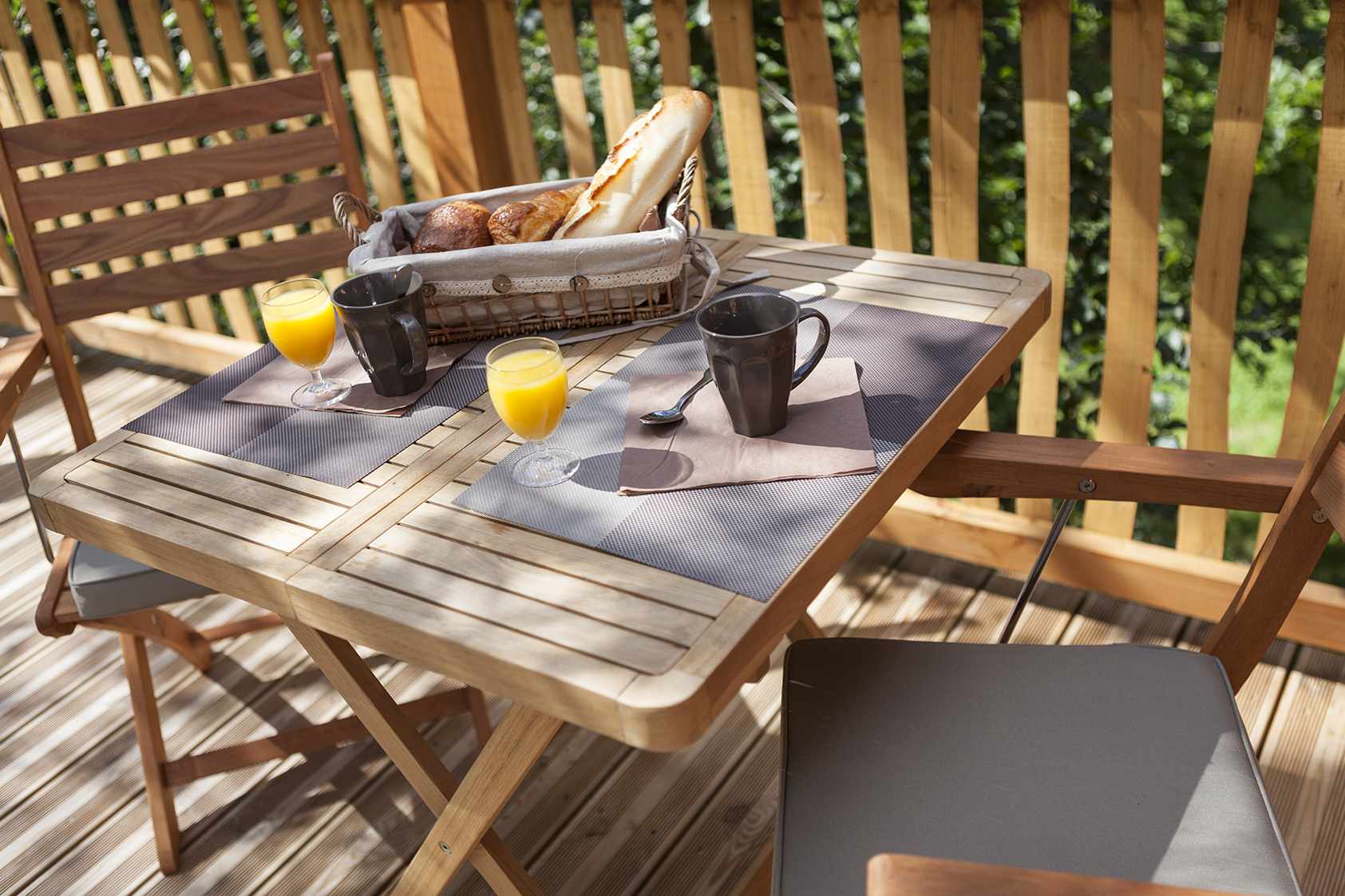 photojp-angei-jp-angei2472 Table en bois sur une terrasse, avec petit-déjeuner et vue sur la nature en Auvergne.