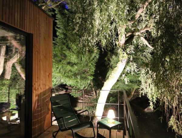 Cabane en bois à Bourgogne, avec terrasse éclairée et vue sur la nature.