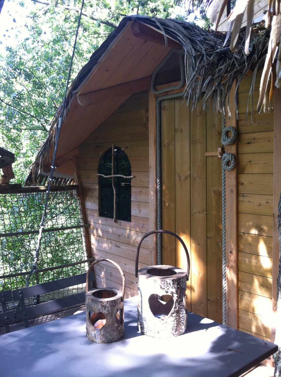 Cabane perchée en bois à lIle-de-France, avec des lanternes en tronc darbre.
