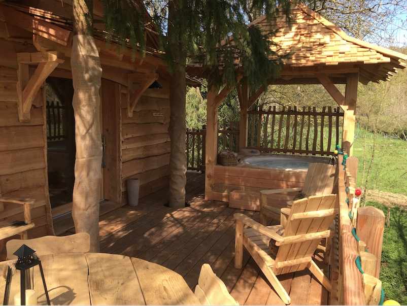 Capture d’ecran 2017-02-13 a 18.37.01 Cabane en bois avec terrasse et jacuzzi, entourée de verdure en Île-de-France.