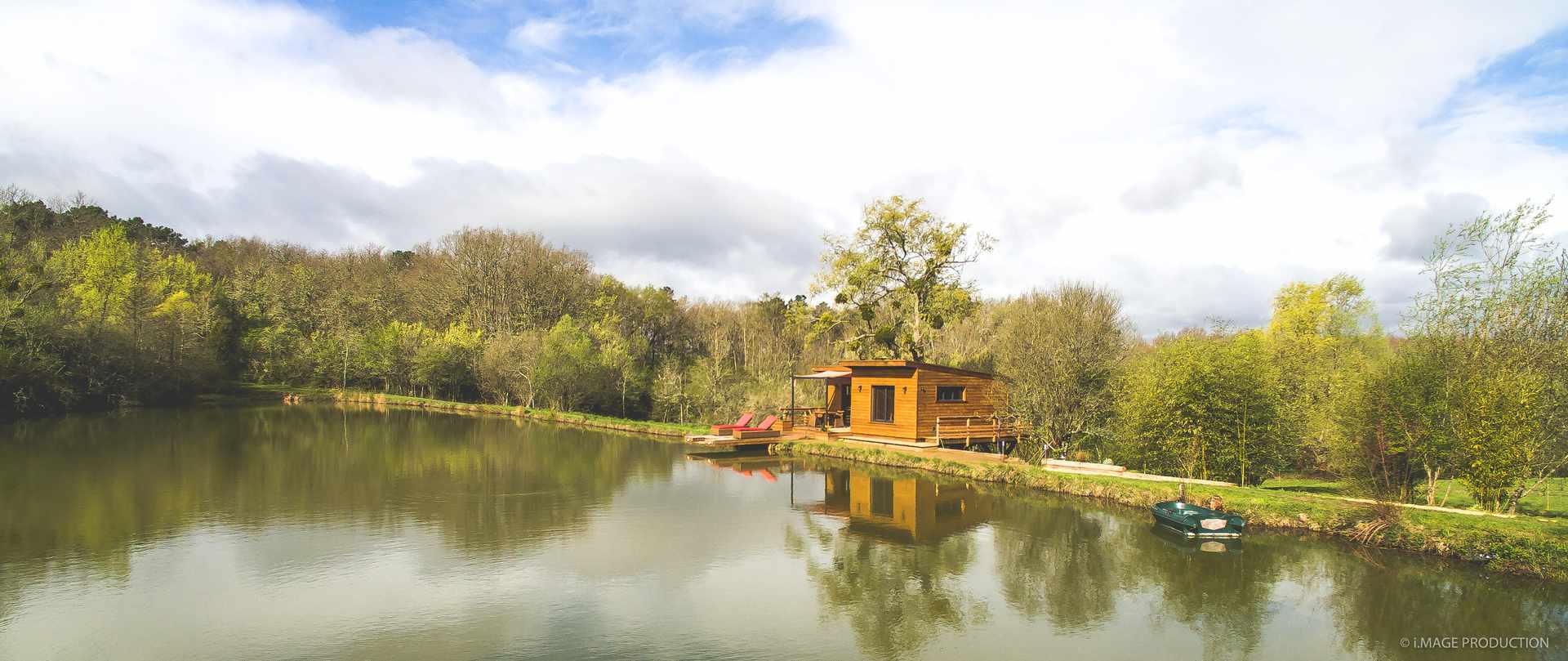 Avril 4low Cabane en bois au bord dun lac, entourée de verdure en Aquitaine.