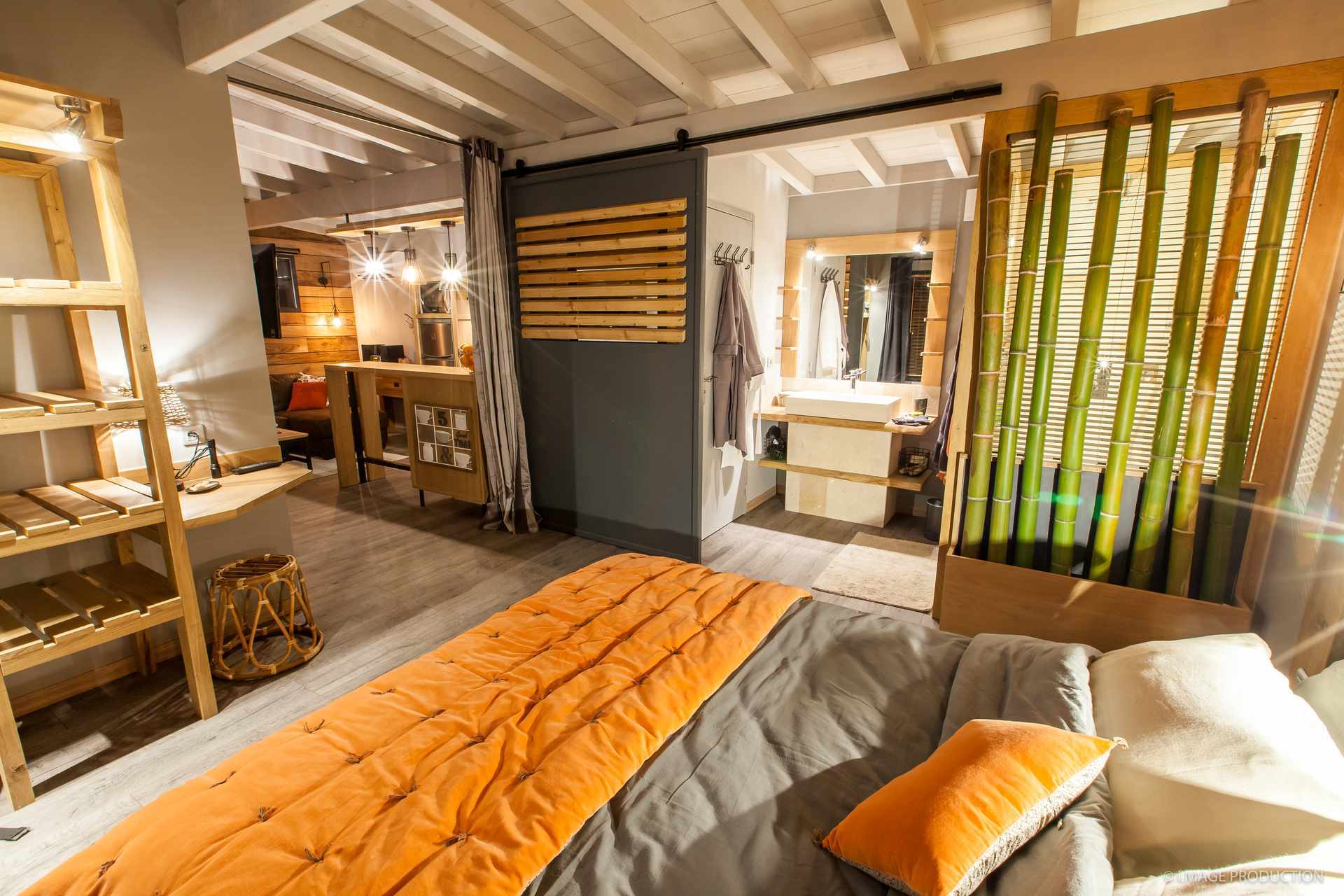 Avril 9low Hébergement insolite en Aquitaine : chambre moderne avec lit orange et décor en bois.