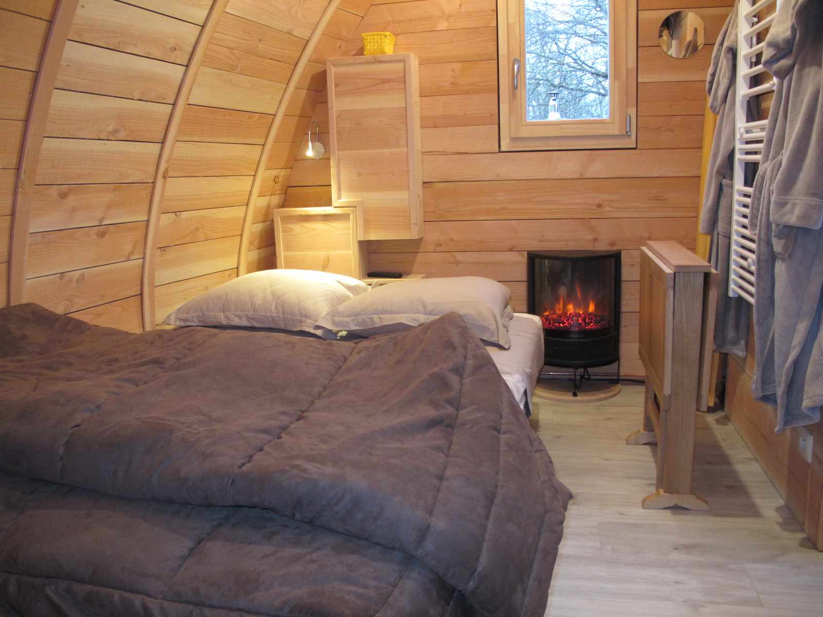 IMG_7411 Hébergement insolite en forme de cabane en bois, avec un lit douillet et un poêle à chaleur.