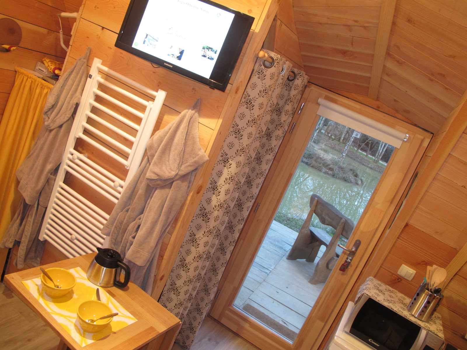 IMG_7413 Hébergement insolite en bois à Champagne-Ardenne, avec vue sur un étang et décor chaleureux.