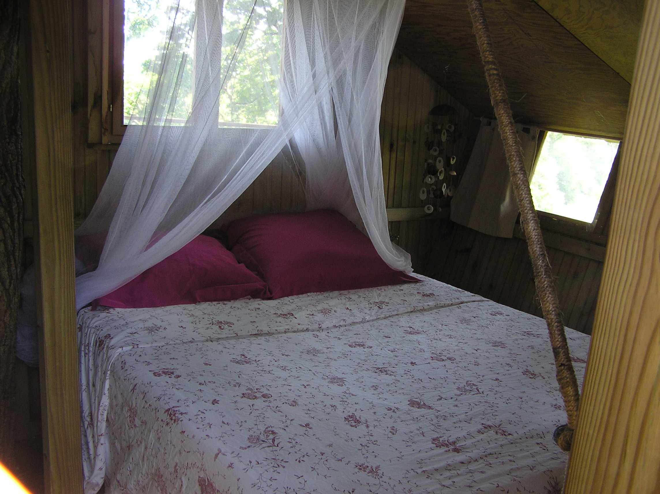 P8100152 Cabane perchée en Bretagne avec un lit douillet et des draps fleuris.