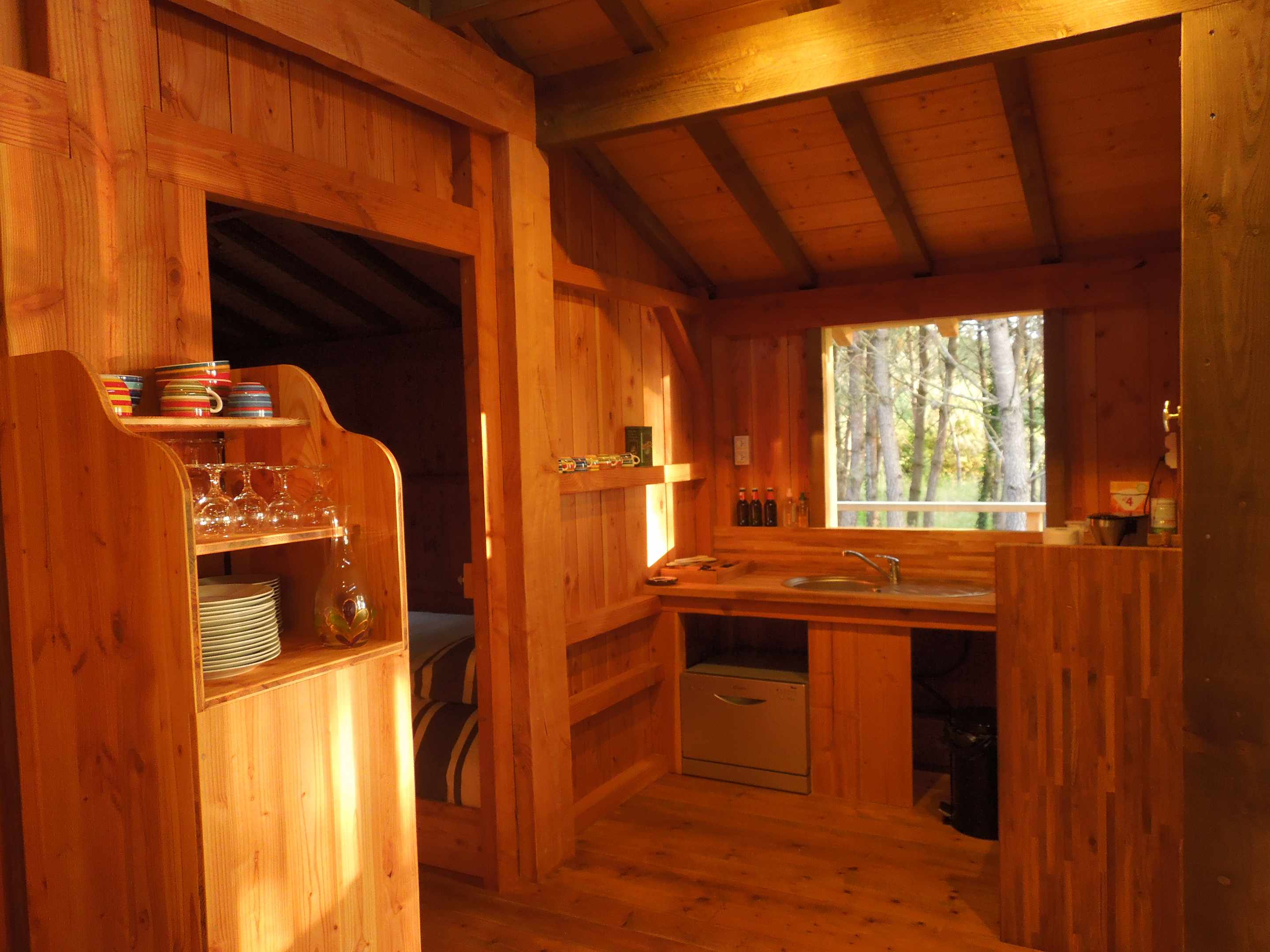 pb_07 Cabane en bois chaleureuse en Aquitaine, avec cuisine ouverte et vue sur la forêt.