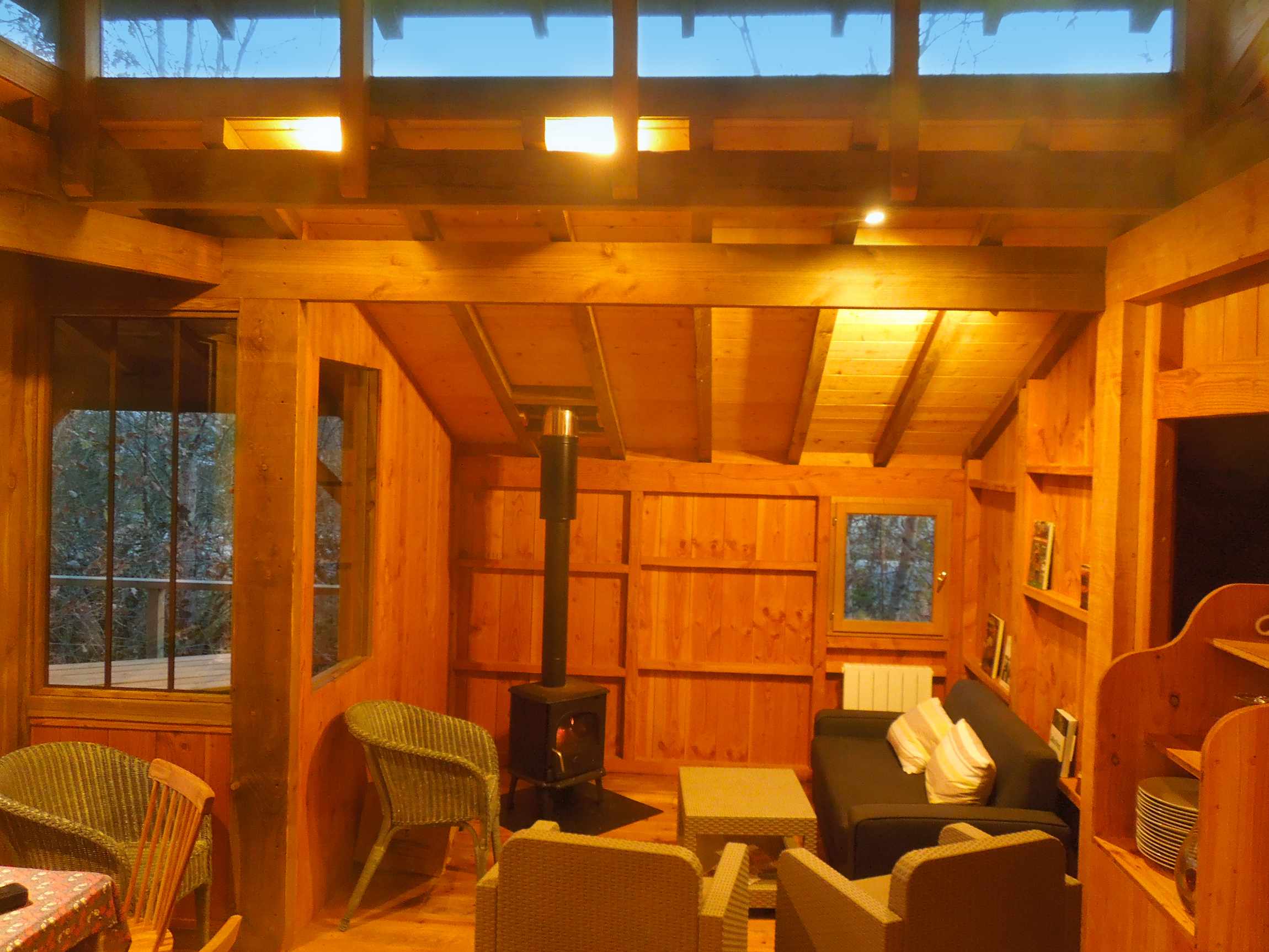 pb_10 Cabane en bois chaleureuse en Aquitaine, avec poêle à bois et vue sur la nature.