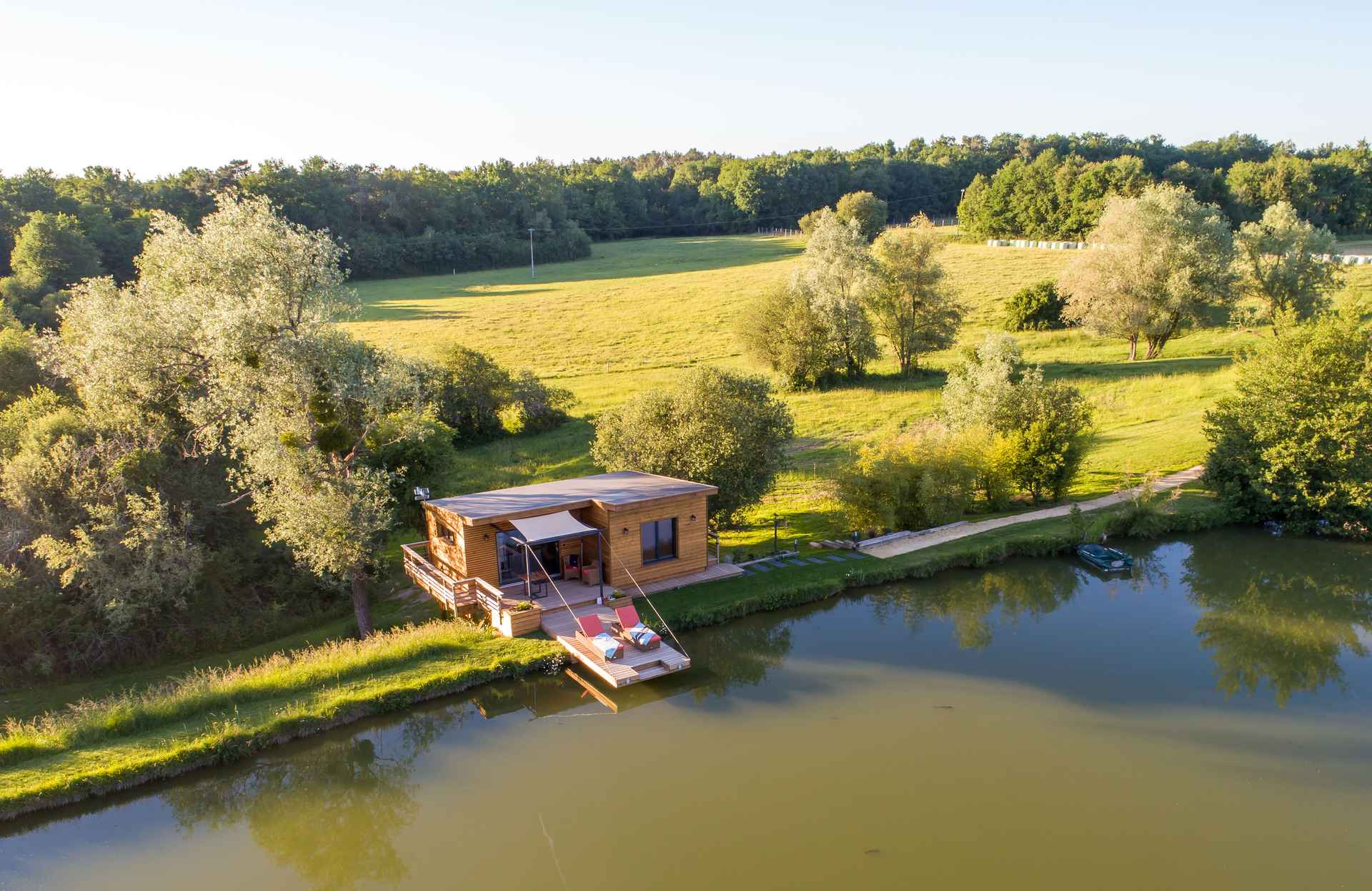 2 Cabane sur pilotis au bord dun lac, entourée de verdure en Aquitaine.