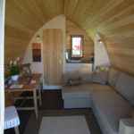 Cabane en bois avec intérieur chaleureux et coin salon confortable.