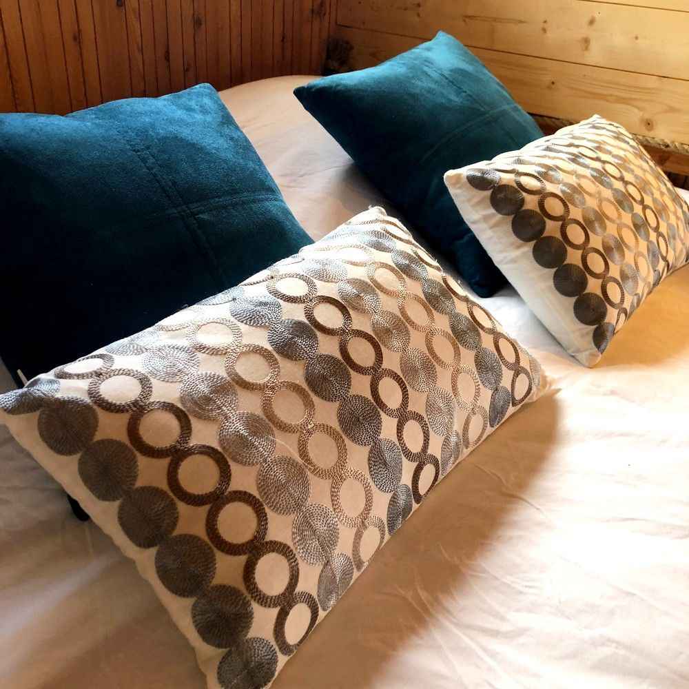 Photo-01-04-2018-12-30-29-compressor Chalet en Bourgogne avec coussins décoratifs colorés sur un lit douillet.