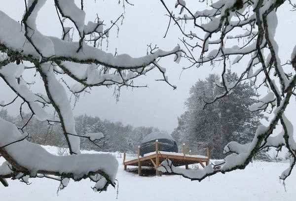 bulleneige Hébergement insolite en Auvergne : yourte sur plateforme, entourée de neige.