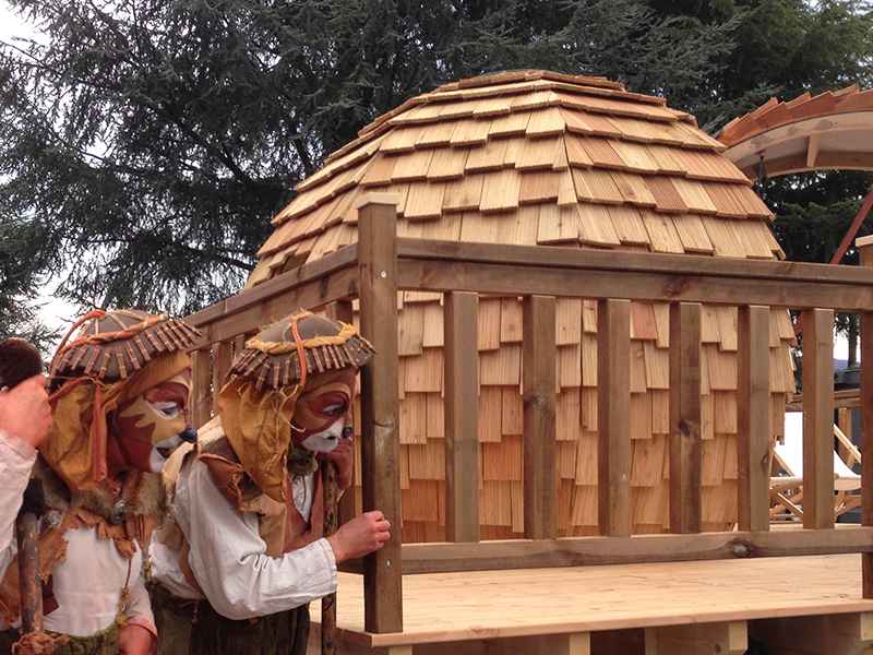 Hébergement insolite en forme de dôme, avec un toit en bois et des personnages costumés.