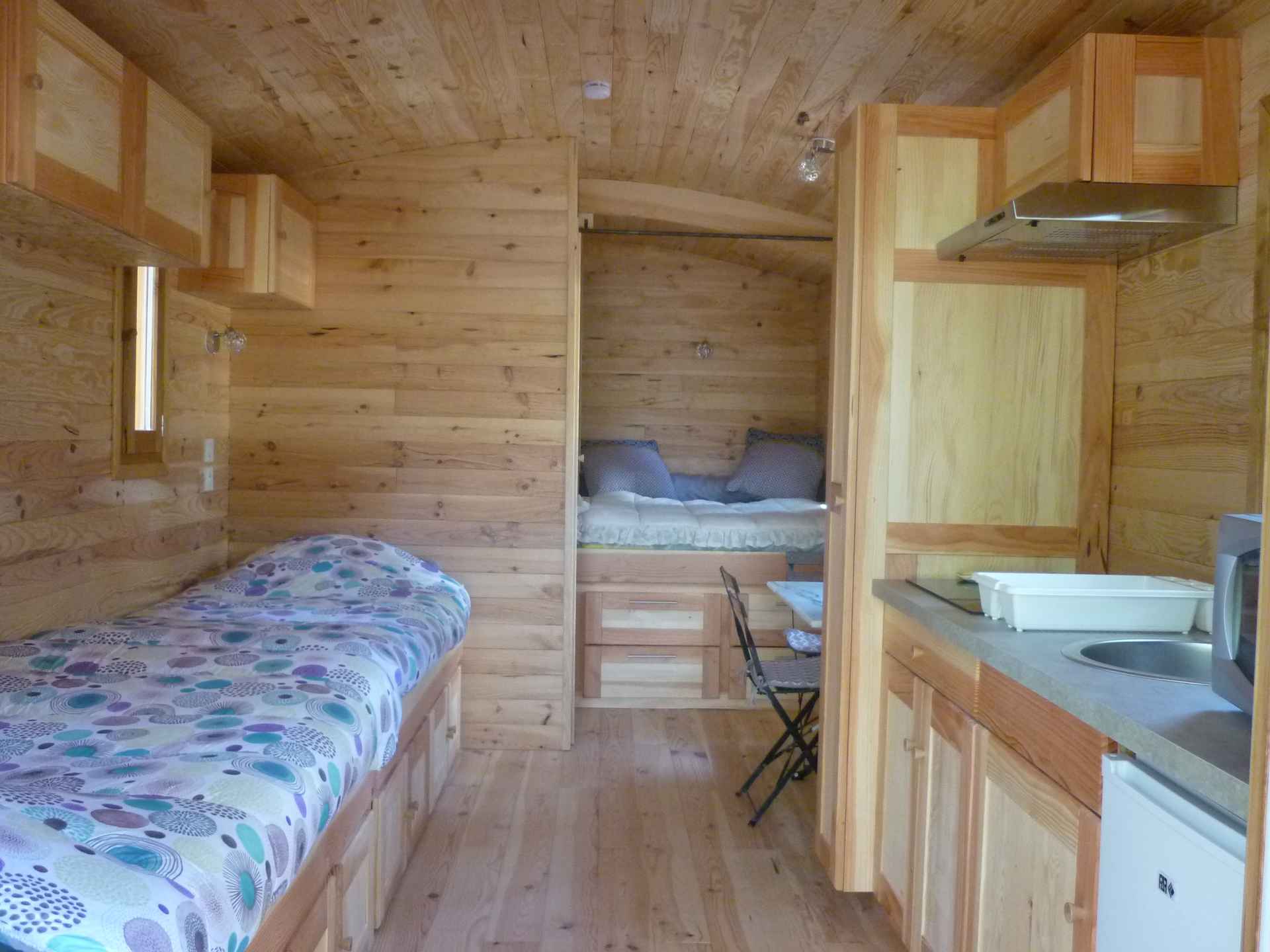 P1060301 Cabane en bois à Languedoc-Roussillon, intérieur chaleureux avec lits et cuisine équipée.