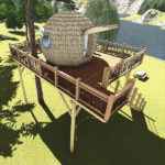 Cabane dans les arbres avec terrasse en bois, vue sur le lac et la nature environnante.