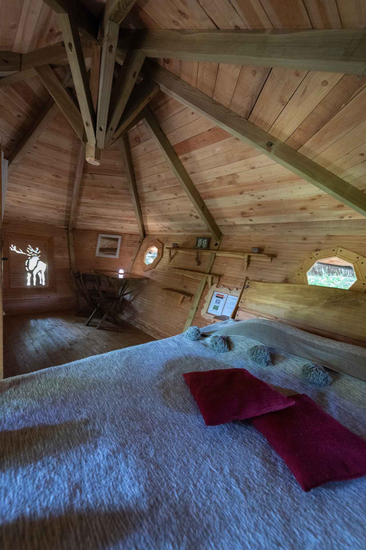 version-internet-35 cerf Cabane en bois avec intérieur chaleureux et fenêtres octogonales. Parfait pour un séjour unique.
