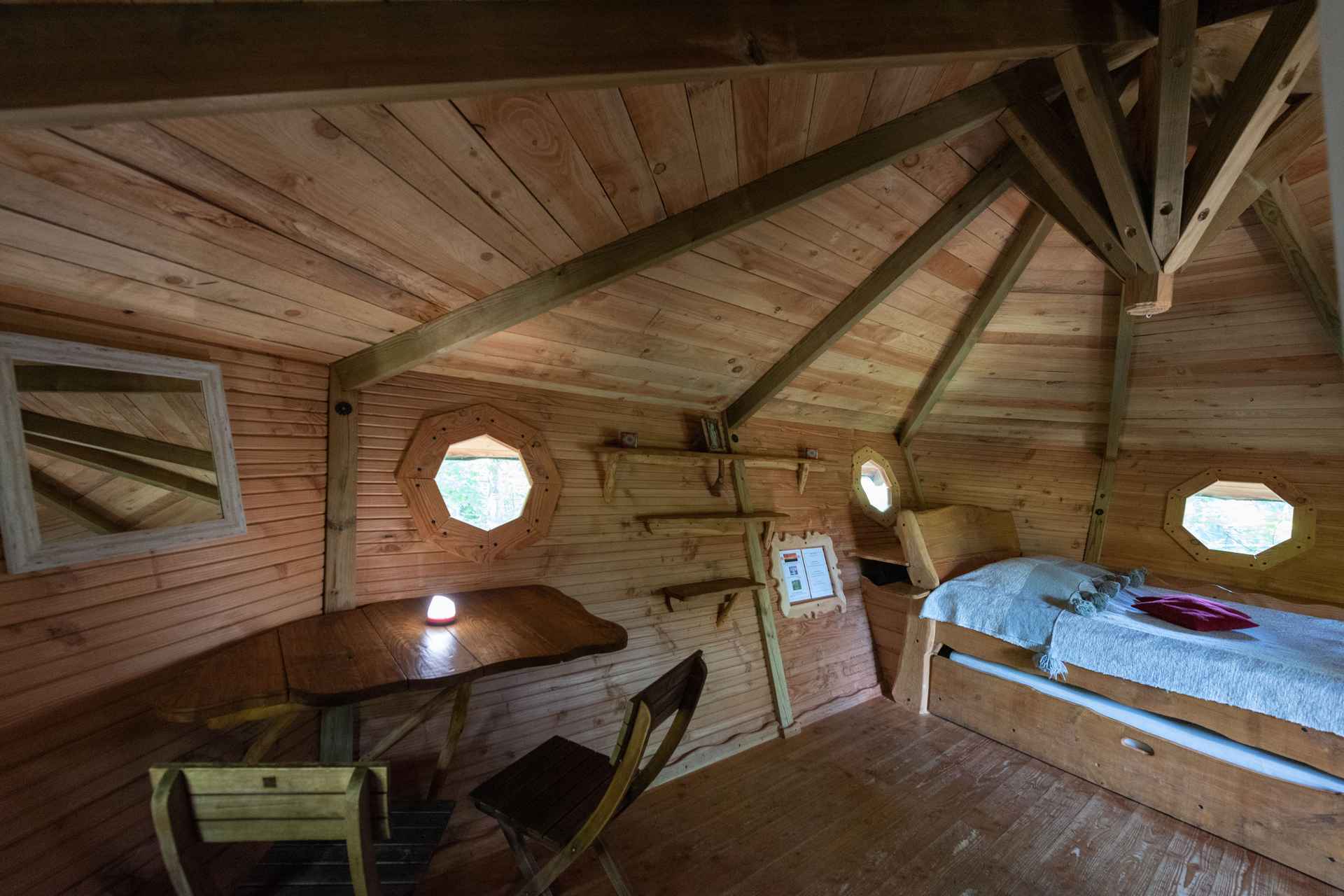 version-internet-36 cerf Cabane en bois avec fenêtres octogonales, offrant une ambiance chaleureuse et naturelle.